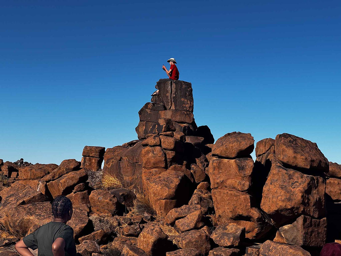 Neil wanted a photo of "me sitting on a rock looking like a cell phone obsessed teenager." Thembe looks sutably confused.