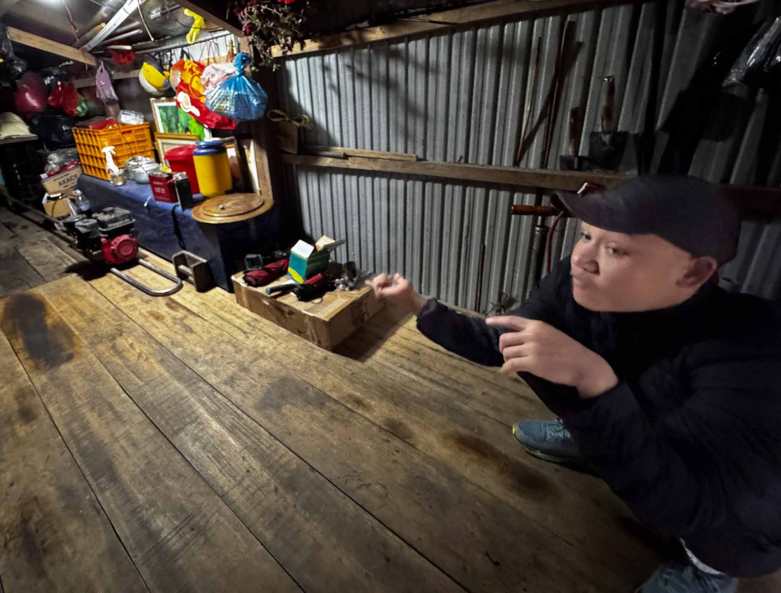 Inside the floating home. Our guide is explaining the blue box, which is a premade coffin. In the tradition of the Ma Coong when you turn 65 you build your own coffin and then throw a party that hundreds of people show up at to celebrate with you.